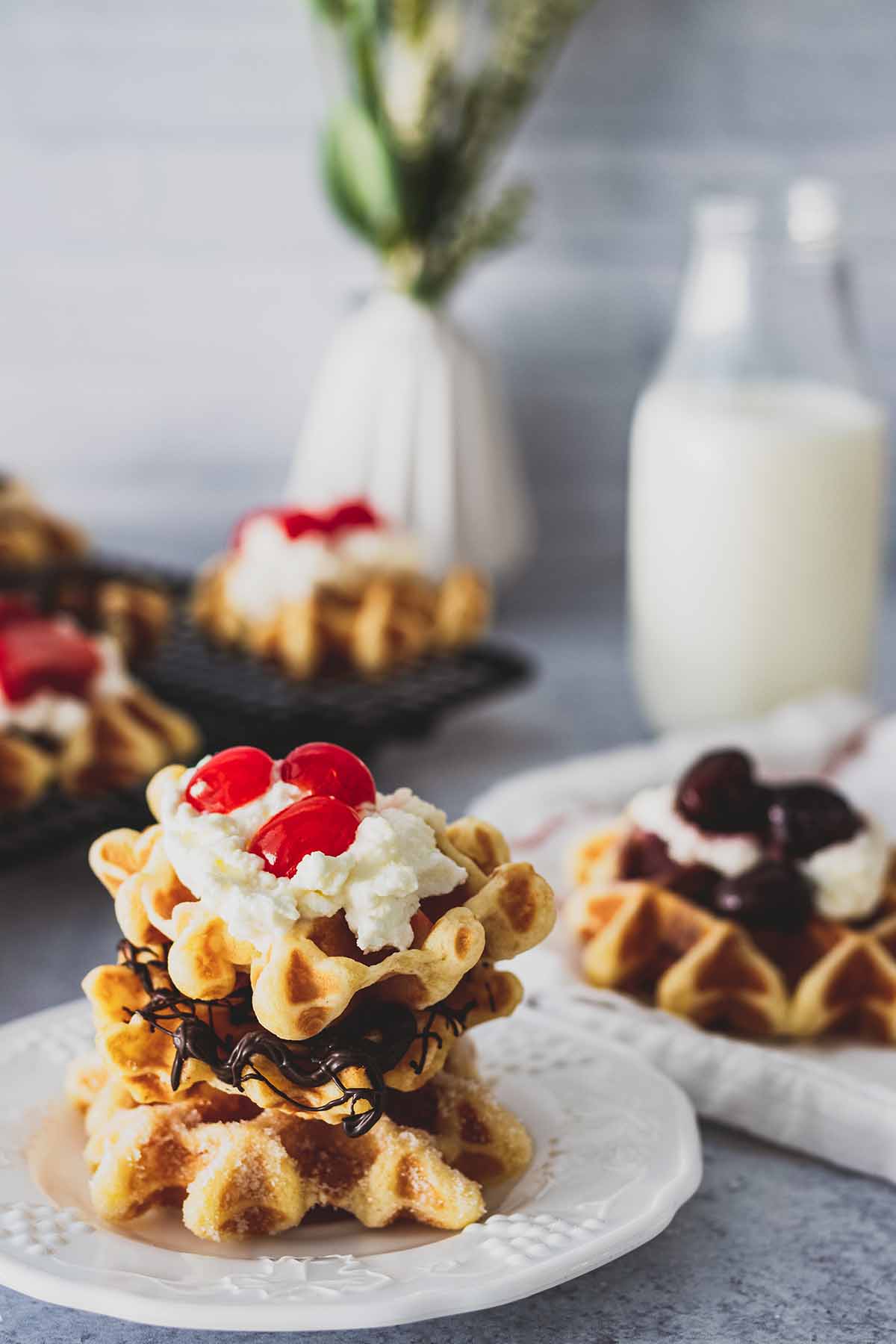 Mini waffles with strawberries, whip cream and chocolate sauce